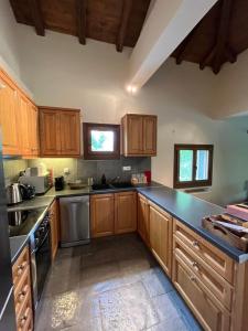a kitchen with wooden cabinets and a black counter top at Happy trails Guesthouse Vitina in Vitina