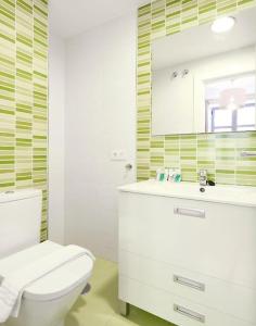 y baño con aseo, lavabo y espejo. en Apartamento ideal para familias en Granada, en Granada