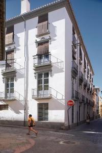 un hombre caminando delante de un edificio blanco en Apartamento ideal para familias en Granada, en Granada