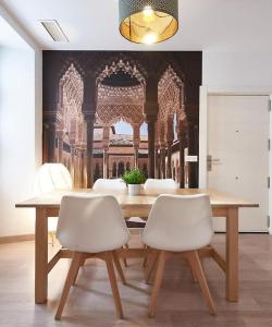 comedor con mesa y 2 sillas blancas en Apartamento ideal para familias en Granada, en Granada