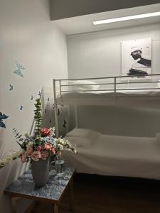 a bedroom with a bunk bed and a table with flowers at Arkadia Hotel & Hostel in Helsinki