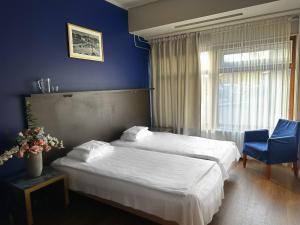 a hotel room with a bed and a blue wall at Arkadia Hotel & Hostel in Helsinki