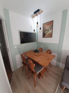 een eetkamer met een houten tafel en stoelen bij Superbe 2 pièces, centre vue Mont-Blanc avec balcon et parking gratuit in Chamonix-Mont-Blanc