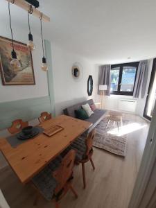 een woonkamer met een tafel en stoelen en een bank bij Superbe 2 pièces, centre vue Mont-Blanc avec balcon et parking gratuit in Chamonix-Mont-Blanc