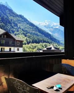 een tafel en stoelen met uitzicht op een berg bij Superbe 2 pièces, centre vue Mont-Blanc avec balcon et parking gratuit in Chamonix-Mont-Blanc