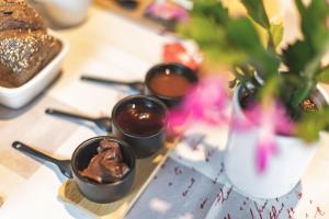a table with four bowls of chocolate pudding and a vase at Chalet Ouréa in Campan