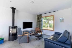 a living room with a blue couch and a fireplace at La Petite Croix Bienvenue in Saint-Cast-le-Guildo