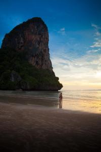 a person standing in the water on a beach at Railay Village Resort in Railay Beach