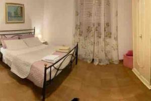 a bedroom with a bed and a window with curtains at A Casa Mia in Albano Laziale