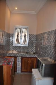 uma cozinha com um lavatório e um micro-ondas em Appartements meublés haut Standing em Bertoua