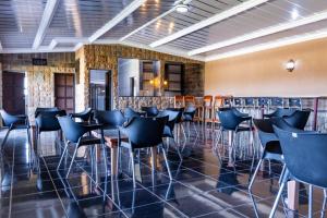 a bar with chairs and tables in a room at Bela Rest Resort in Bela-Bela