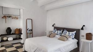 ein Schlafzimmer mit einem weißen Bett mit blauen und weißen Kissen in der Unterkunft Casa Don Michele in Letojanni