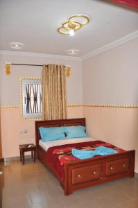 een slaapkamer met een bed en een raam bij Appartements meublés haut Standing in Bertoua