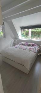 a bed in a white room with a window at Lauwie 14 in Lanaken