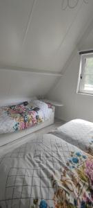 two beds in a white room with a window at Lauwie 14 in Lanaken