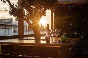 een tafel met wijnglazen en een boom op een balkon bij Ethereal Athεns in Athene