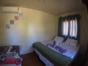 Habitación pequeña con cama y ventana en Pousada das Ilhas, en Fernando de Noronha