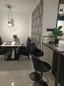 a dining room with black chairs and a table at APARTAMENT KOSMOS GORZOW in Gorzów Wielkopolski