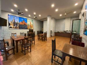 a restaurant with tables and chairs and a large painting on the wall at 77 Patong Hotel & Spa in Patong Beach