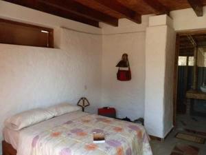 1 dormitorio con 1 cama y una foto de una mujer en la pared en Fundo Matufa Mancora, en Canoas de Punta Sal