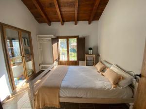 een slaapkamer met een groot bed in een kamer met ramen bij Casa Rural con Jacuzzi junto a Camprodon. in Abella