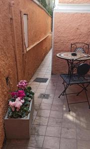 eine Terrasse mit einem Tisch, einem Tisch und Blumen in der Unterkunft Camere Chicca in Sanremo