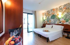 um quarto de hotel com uma cama e uma taça de fruta em Hotel Falcone em Lignano Sabbiadoro