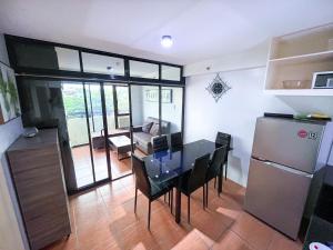 a kitchen and dining room with a table and a refrigerator at Modern 2BR Condo Near SM with Free Parking Pool WIFI and Netflix in Davao City