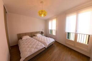 um quarto com uma cama e duas janelas em La Casa Machado 2 em Collioure