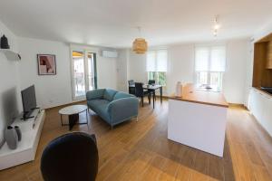 a living room with a blue couch and a kitchen at La Casa Machado 2 in Collioure