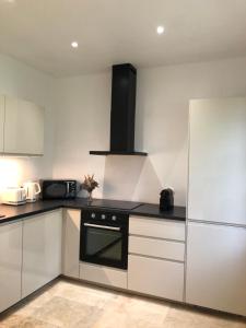 a kitchen with white cabinets and a black oven at MANOIR DE CLERMONT in Saint Malo