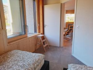 een kamer met een bed, een raam en een deur bij Le Fleuron - Cosy and well centered - 6 ppl in Nendaz