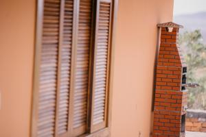 a window with a brick pillar next to a window shutter at Villa Annapurna in Alto Paraíso de Goiás