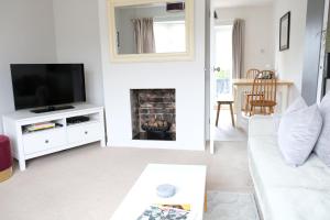 a living room with a white couch and a fireplace at Chaloners House, Free Parking, Large garden, Close to York Races & City Centre in York