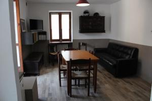 Gravere的住宿－Casa Milietta，客厅配有桌子和沙发