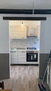 a kitchen with white cabinets and a stove top oven at Casa Milietta in Gravere