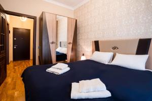 a bedroom with a large blue bed with towels on it at Просторная квартира Баку in Baku