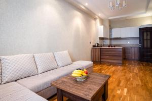 uma sala de estar com um sofá e uma tigela de fruta numa mesa em Просторная квартира Баку em Baku