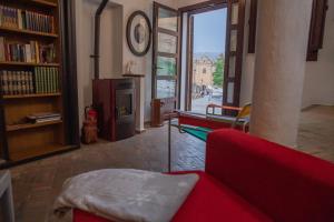 a living room with a red couch and a fireplace at El Pensamiento Duplex in Ronda