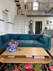 a blue couch in a living room with a table at Himelsk in Koudum