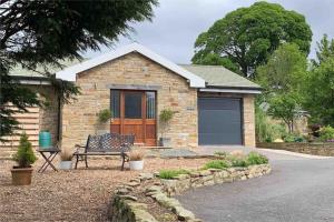 a brick house with a bench in front of it at Sunset View a quiet and romantic rural retreat for 2 adults just outside ingleton in Ingleton 