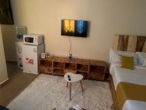 a bedroom with a bed and a television on the wall at Ruby Modern Homes Studio-Imara Daima,Behind Imaara Mall-JKIA-Horizon in Nairobi