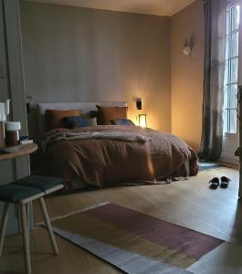 a bedroom with a bed and a chair and a window at La Chambre du 21 in Trouville-sur-Mer