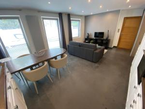 a living room with a table and chairs and a couch at Wimereux : calme, proche du centre et de la plage in Wimereux