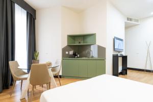 ミラノにあるCastello Guest House Milanoのテーブルと椅子、キッチンが備わる客室です。
