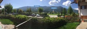 a fence in front of a parking lot with cars at Hernegg Apartment in Riscone +3 photos