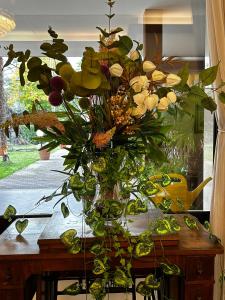 eine Vase voller Blumen auf einem Tisch in der Unterkunft Hotel Rey's in Montegrotto Terme