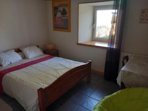um quarto com uma cama e uma janela em La sérénité em Grazac