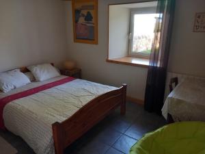 a bedroom with a bed and a window at La sérénité in Grazac
