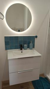 ein Badezimmer mit einem weißen Waschbecken und einem Spiegel in der Unterkunft Maison d'hôtes calme proche village in Bédoin